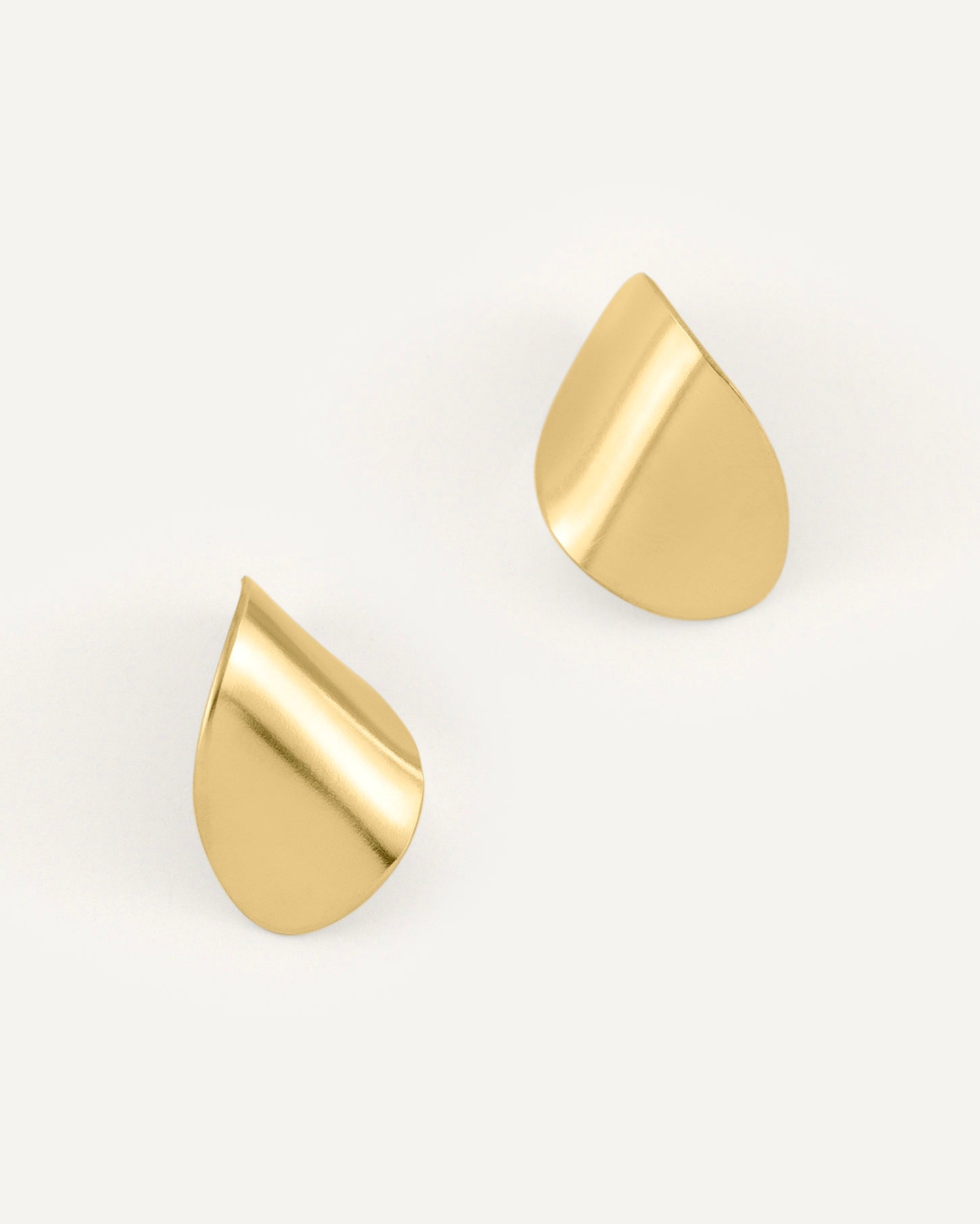 A pair of clean line and leaf-shaped brass earrings in high polished finish.