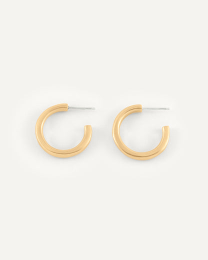 A pair of organic and fluid shape brass hoops in soft satin finish.